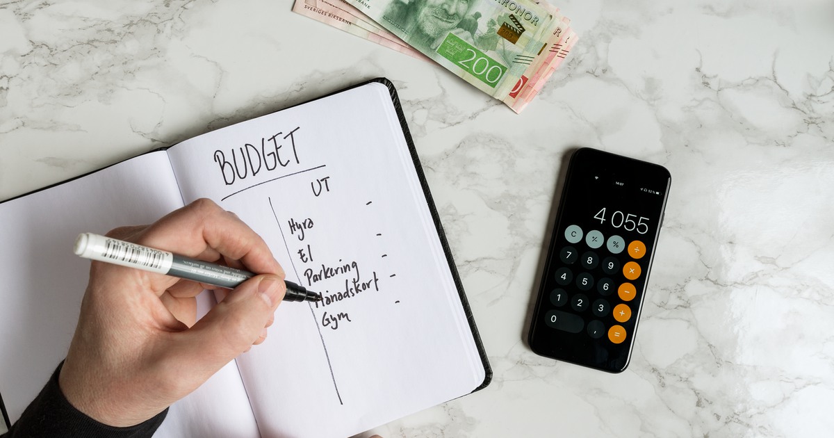 Pengar, mobil, anteckningsblock och hand som räknar budget