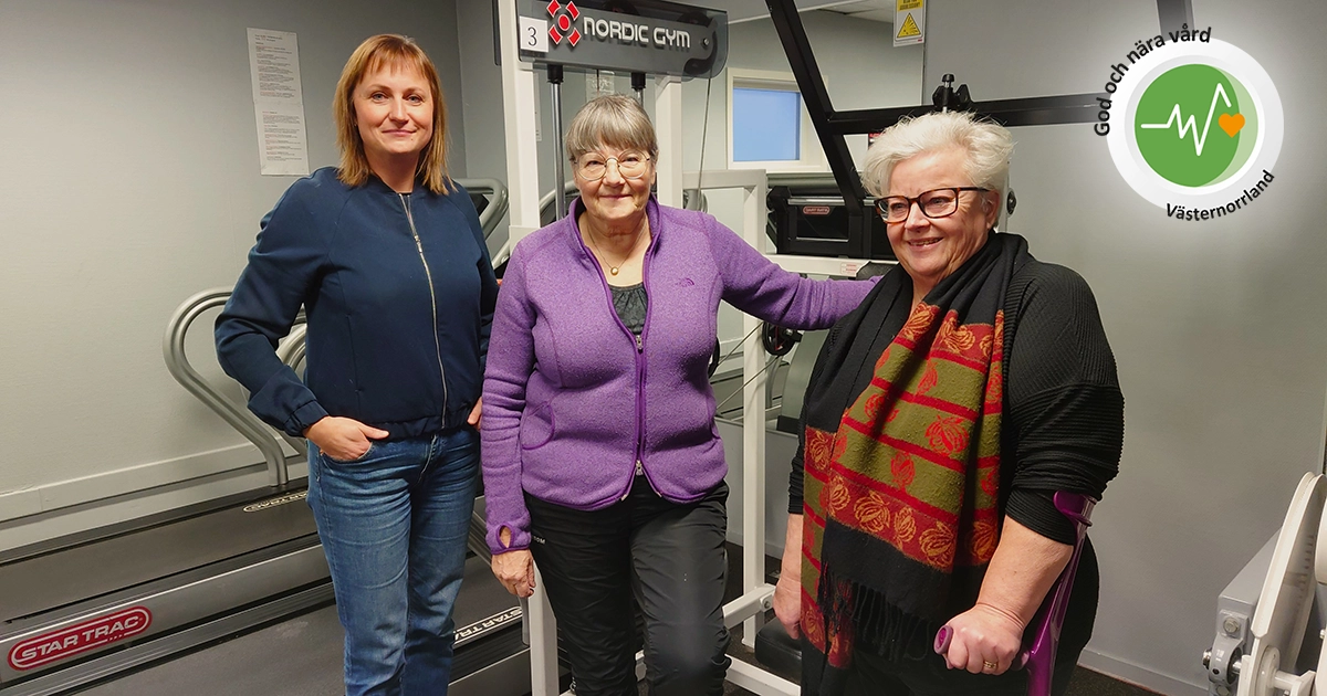 Tre kvinnor står framför en träningsmaskin i gymmet.
