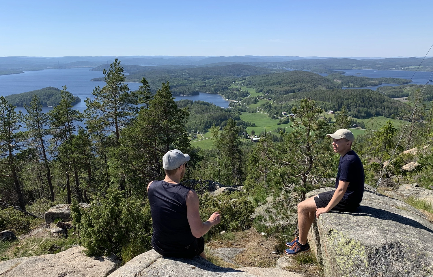 Två unga män sitter på klipporna på berget Valkallen och samtalar.